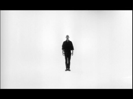 Max standing on a completely white room, reciting numbers
