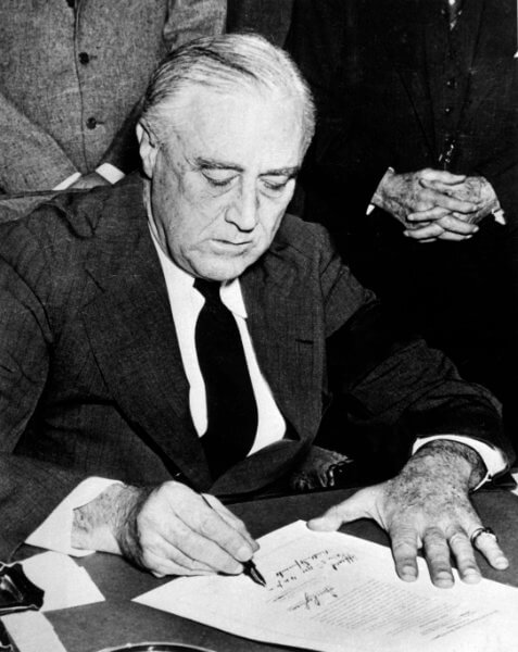 Franklin Roosevelt signing declaration of war against Japan